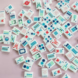 White Mahjong tile set from the House Collection, featuring intricately designed tiles with floral motifs, butterflies, and peacocks. Tile size: 1" x 1 7/16" x 7/16".