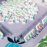 Classic white Mahjong tile set featuring colorful symbols in red, blue, and green arranged in suits and specialty tiles, displayed on a white background.