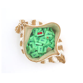 White and tan striped raffia Mahjong bag with green Mahjong tiles inside