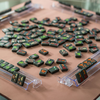 Dark Mahjong tiles on a brown Mahjong mat with orange stars in two corners